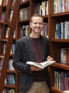 Dan Jacobsen, grandson of Warren W. Wiersbe standing in his grandfather's reading library at Cedarville University
