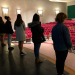 students standing on stage in an empty auditorium