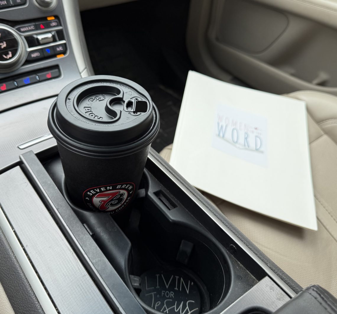 scene inside car with a coffee cup and a folder